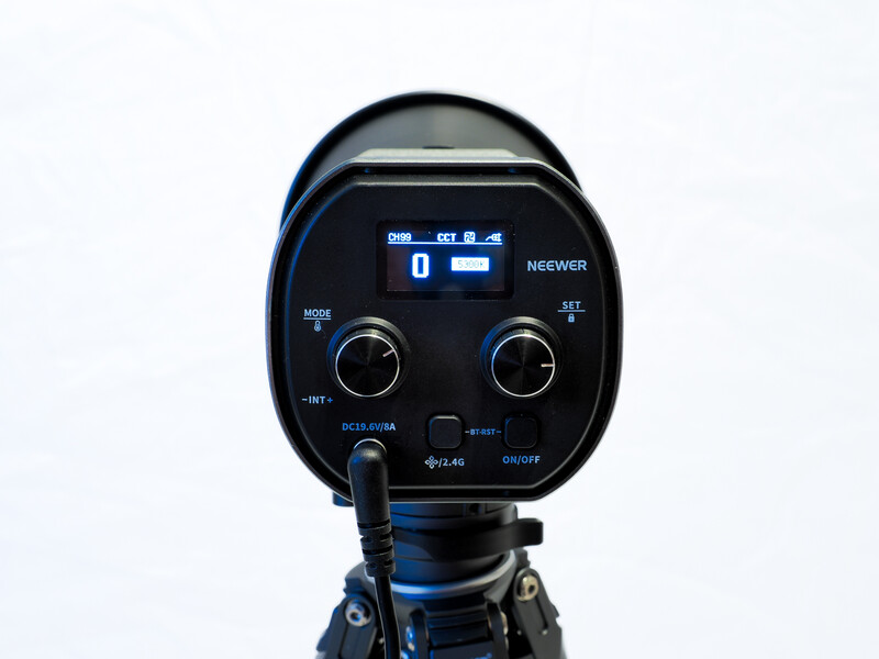 Neewer LED video light with digital control panel mounted on tripod against white background.