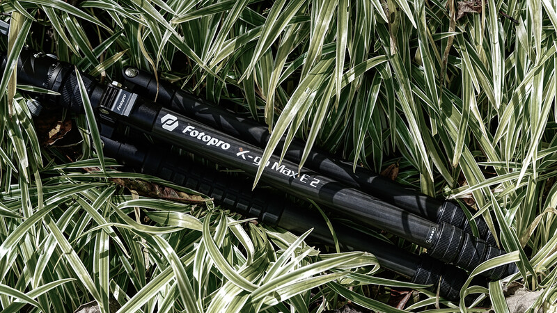 Paxvato K-series rifle scope lying on variegated green and white ornamental grass.