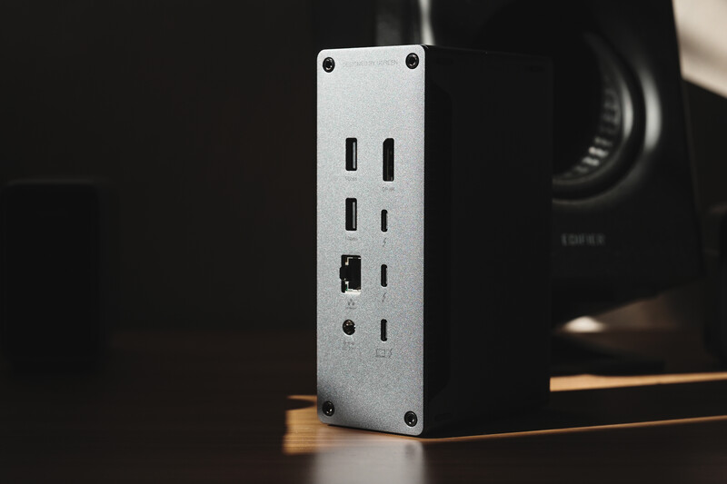 White metal expansion dock with multiple USB-C ports and Ethernet connection mounted vertically on a desk.