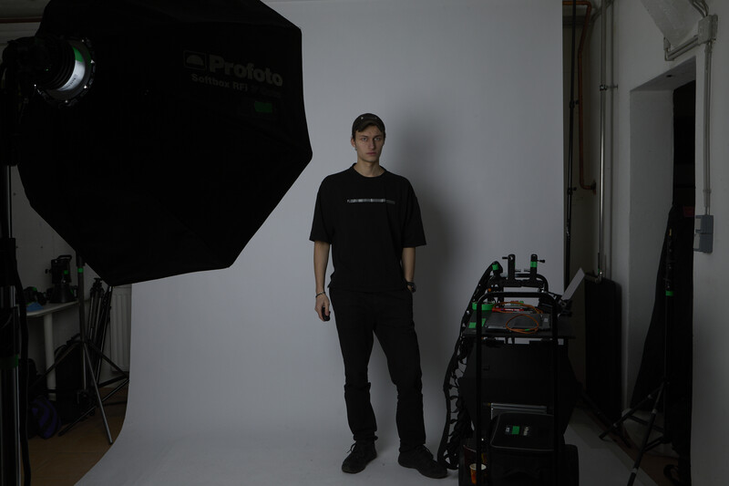 Portrait of a person standing in a photography studio with professional lighting equipment.