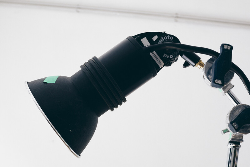 Studio strobe with reflector attached to an articulated arm and mounting bracket.
