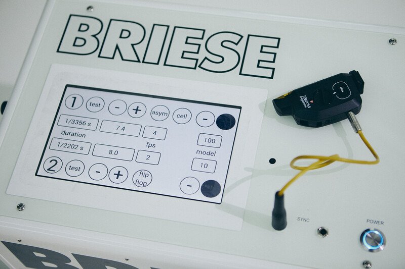 Briese studio lighting equipment control panel with attached flash head and yellow sync cable.