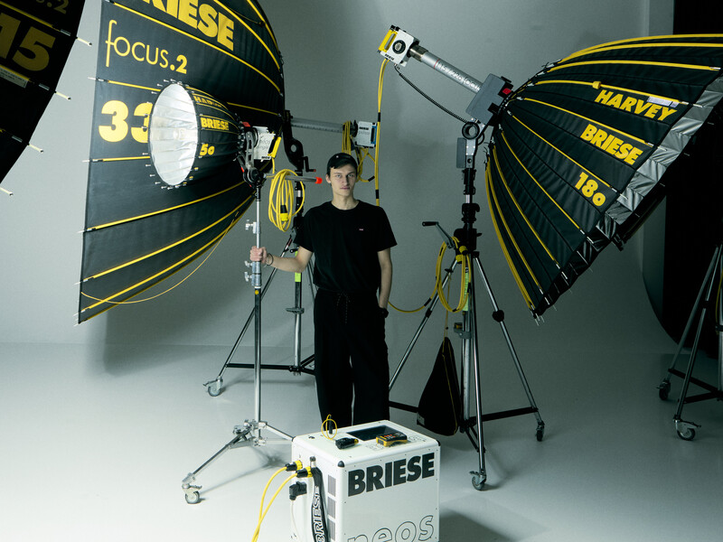 Professional studio lighting setup with parabolic reflectors and a person standing in the center.