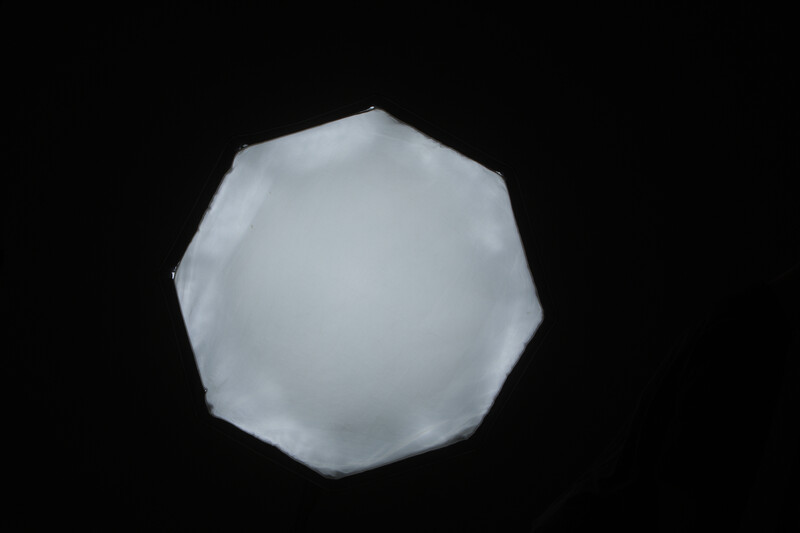 Three-dimensional white geometric sphere with faceted polygonal surface against black background.