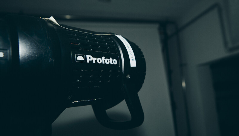 Profoto studio flash head with dome diffuser mounted on lighting stand indoors.