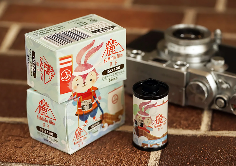 Vintage film camera with retro product packaging featuring illustrated character designs.