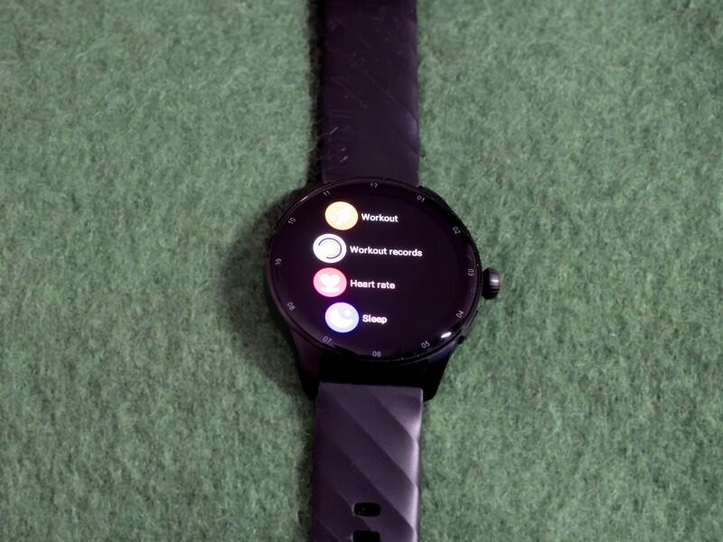 Smartwatch with dark display showing a menu of fitness tracking options including workouts, heart rate, and sleep.