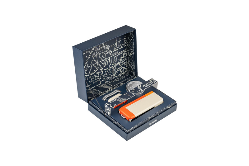 Open equipment case containing camera gear, cables, and an orange battery or power module.
