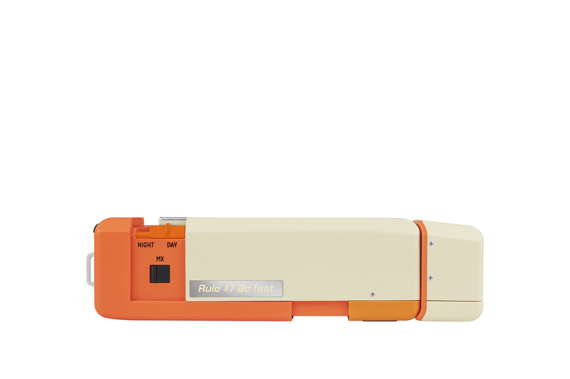 Vintage orange and cream instant camera with manual controls and viewfinder on top.
