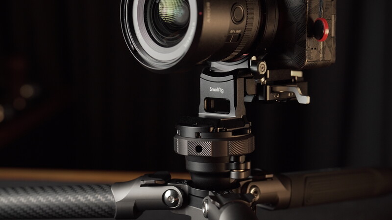 Cinema lens mounted on a gimbal stabilizer with carbon fiber arm against dark background.