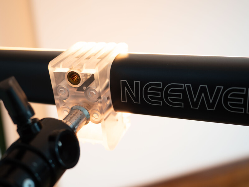 Translucent camera mounting bracket attached to a black handlebar or rail.