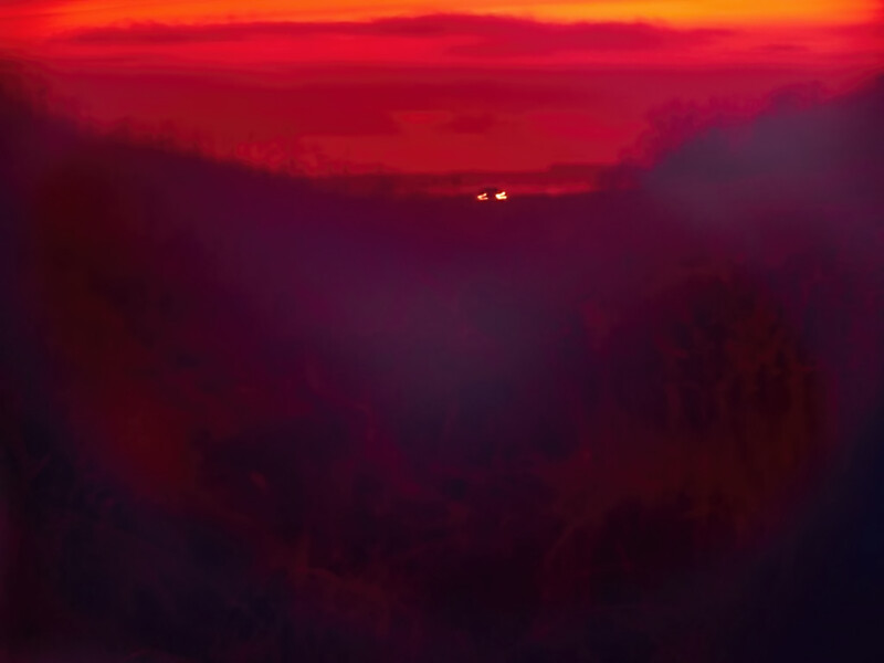 Dramatic sunset over mountains with distant vehicle headlights visible on the horizon.