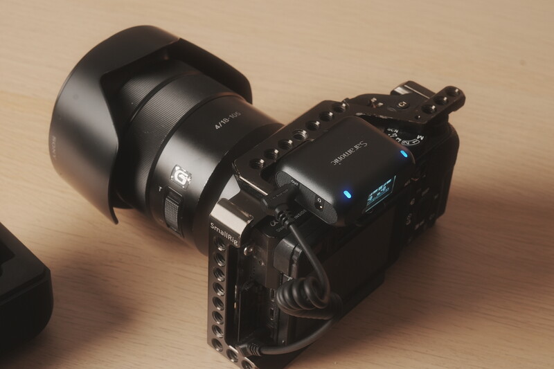 Professional video camera with wide-angle lens and lens hood on wooden surface.