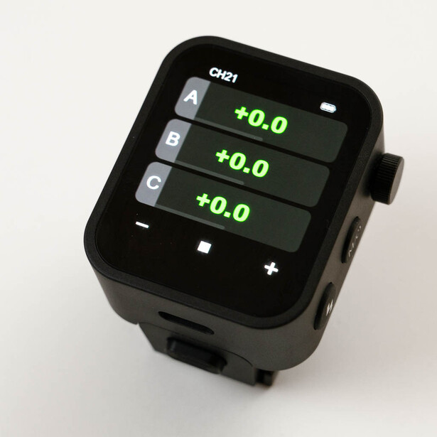 Digital exposure compensation device displaying three channels each set to +0.0 on a black screen.