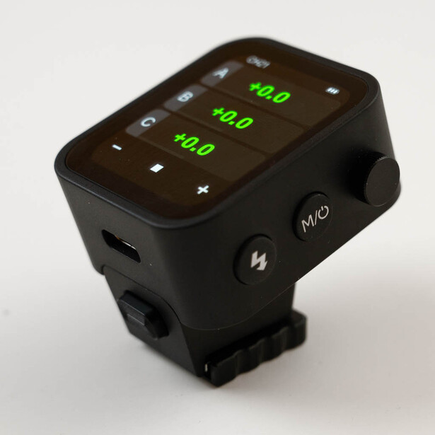 Black wireless flash trigger with illuminated green display showing three frequency readings of 40.0.