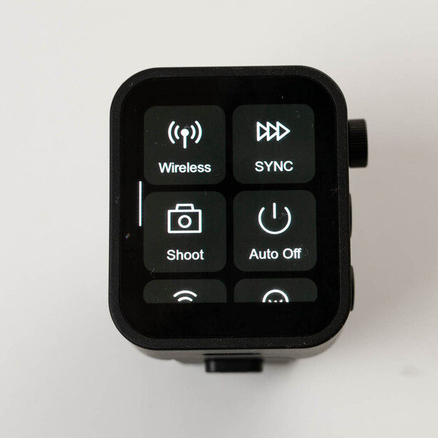 Black wireless remote control with six buttons labeled Wireless, Sync, Shoot, Auto Off, and two additional function buttons.