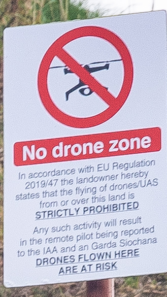 Sign graphic displaying a no-drone symbol with red circle and slash over a drone silhouette.