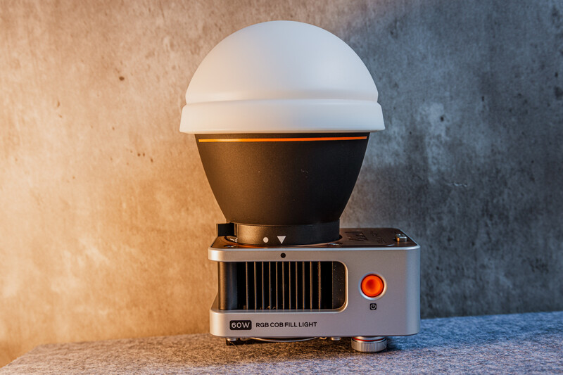 Vintage dome-shaped light fixture with white diffuser and bronze-colored base on textured surface.