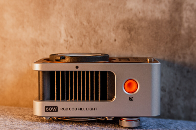 60W RGB fill light with compact design, featuring ventilation grilles and orange power indicator on textured surface.