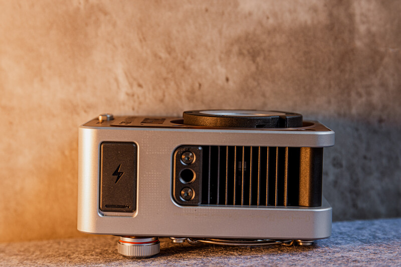 Vintage compact camera with silver body, black lens assembly, and lightning bolt symbol on side panel.