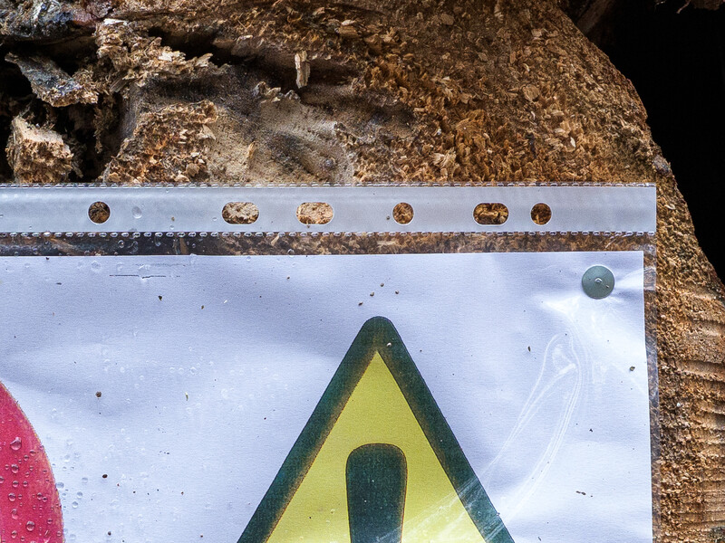 Measurement scale and warning triangle symbol on textured surface during documentation.
