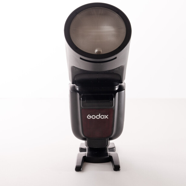 Godox flash unit mounted on stand with dome diffuser attachment.
