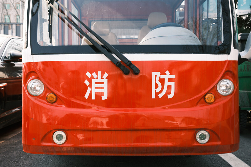 Front view of a red fire truck with Chinese characters and dual headlights.