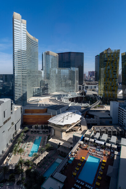 Aerial view of urban downtown skyline with mixed-height modern buildings and blue sky.