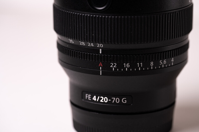 Sony FE 4/20-70 G zoom lens with aperture ring and focus distance scale visible.