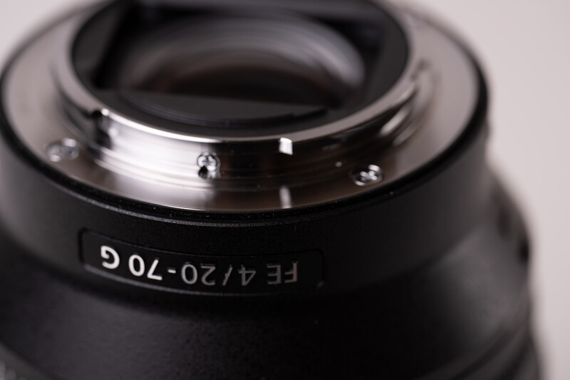 Close-up of a camera lens showing focal length markings and glass elements through the front optics.