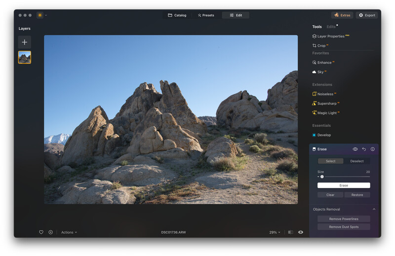 Screenshot of photo editing software displaying a rocky desert landscape with jagged rock formations under clear blue sky.