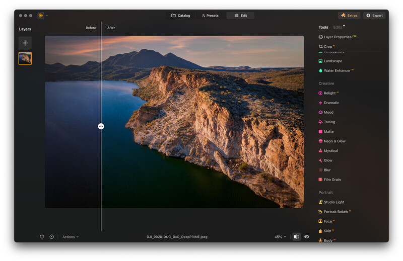 Screenshot of photo editing software showing a coastal landscape with rocky cliffs and blue water under warm sunset light.