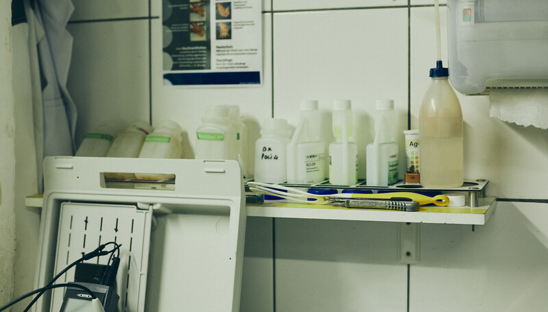 Interior of a refrigerator shelf displaying cleaning and household product bottles with minimalist white and green labeling.