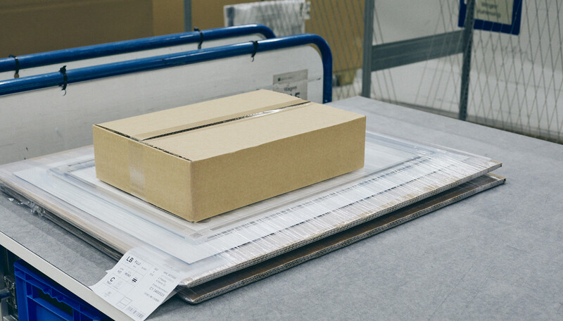Cardboard box placed on architectural material samples arranged on a work table.