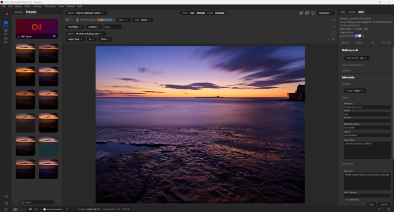 Rocky shoreline at sunset with purple and orange sky reflecting on calm water.