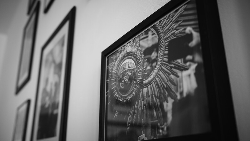 Black and white framed artwork displaying ornate circular medallion design with radiating lines and profile silhouette.