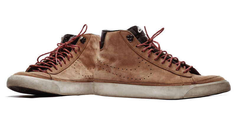 Tan suede high-top sneaker with perforated detailing and burgundy laces, shown from the side on white background.