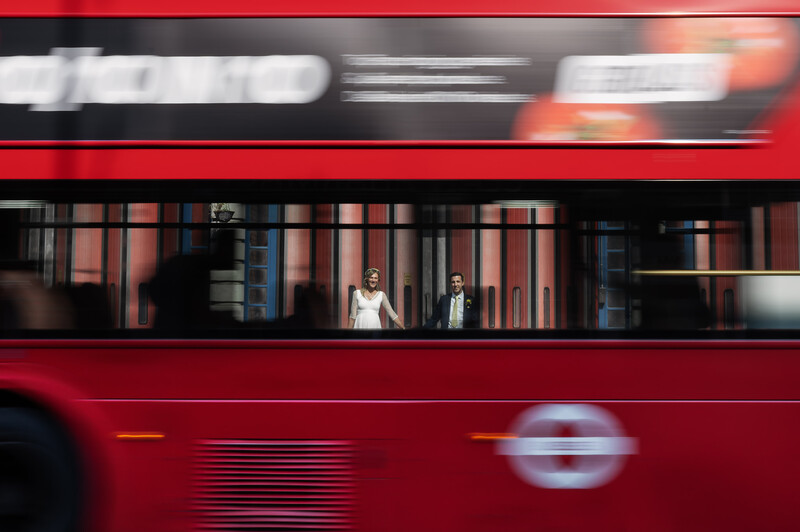 Red double-decker bus in motion with passengers visible through windows, shot with motion blur effect.