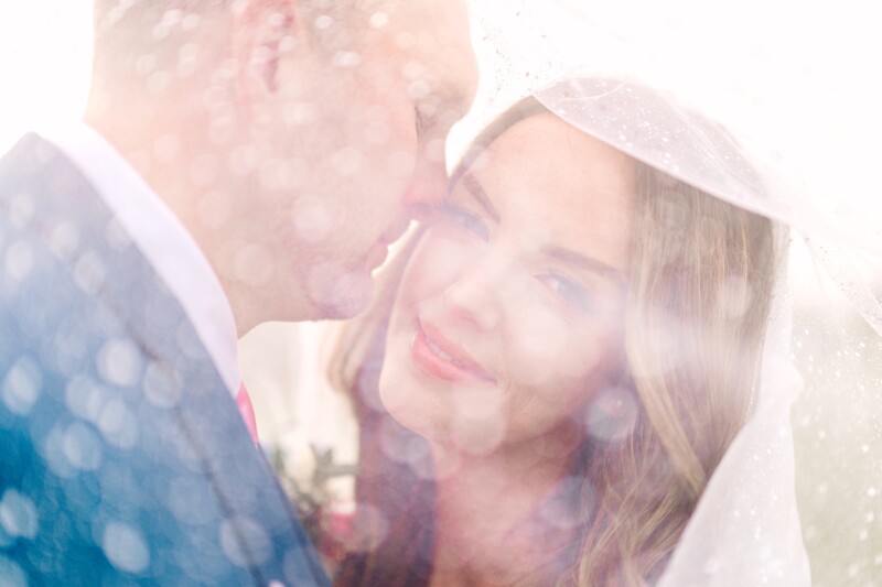 Two people in close embrace with soft, dreamy double-exposure overlay effect.