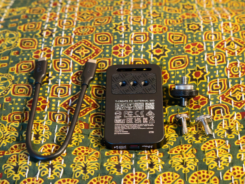 Power adapter and cables arranged on patterned fabric background.