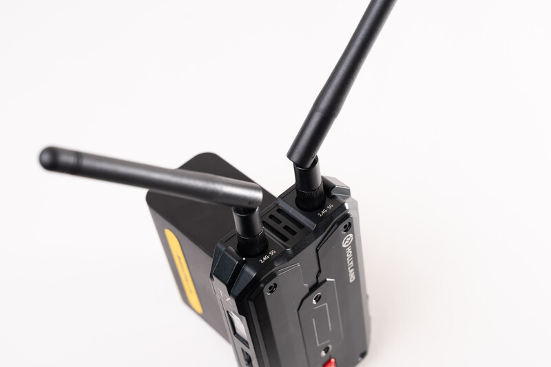 Black two-way radio with extended antenna and yellow accent stripe on battery.