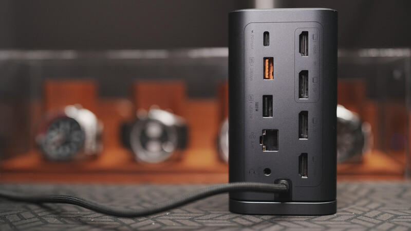 Cylindrical power strip with multiple USB ports and outlets, shot against a blurred warm-toned background.