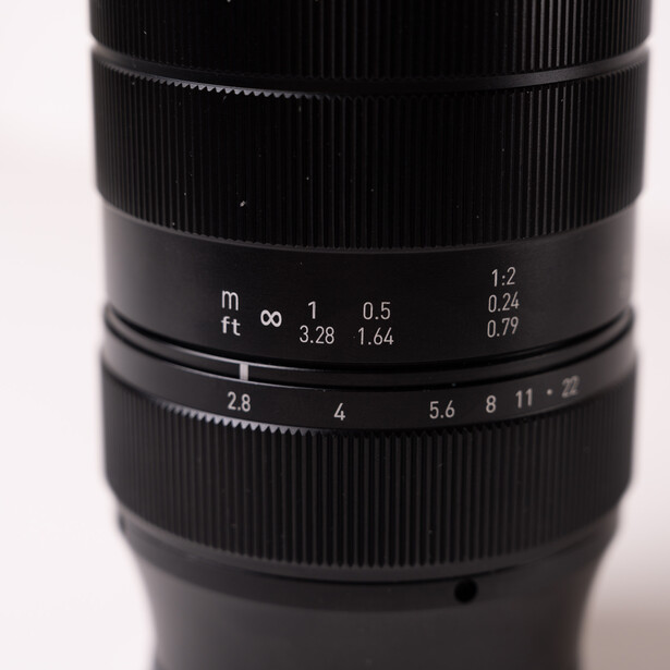Close-up of a vintage lens showing aperture and focus distance scales with markings.