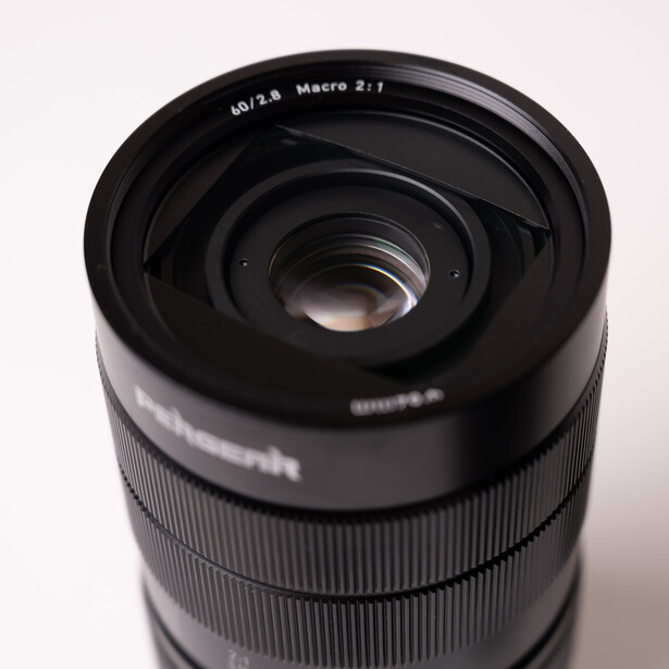 Close-up view of a telephoto zoom lens with visible focal length and macro markings on the barrel.