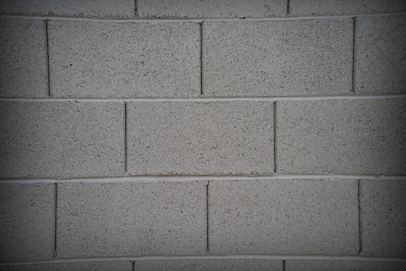 Close-up of concrete cinder block wall with running bond pattern and mortar joints.