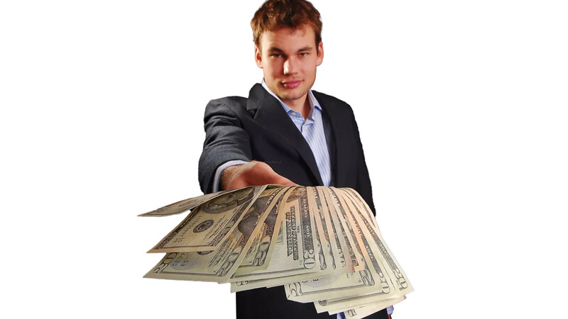 Man in business attire extending fanned U.S. dollar bills toward camera.