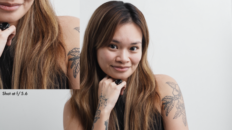 Two women with long brown hair and visible tattoos on their arms pose together against a white background.