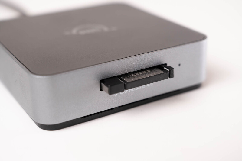 Mac mini computer with dark gray top panel and white base, showing front-facing HDMI port detail.