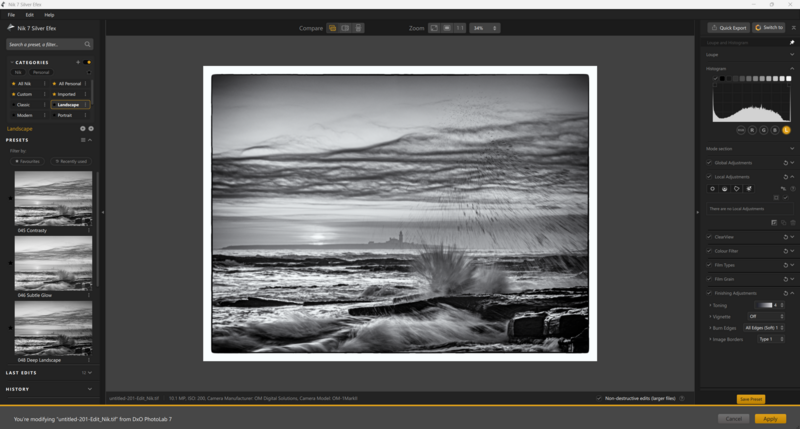 Black and white seascape with crashing waves against rocky shore under dramatic cloudy sky.