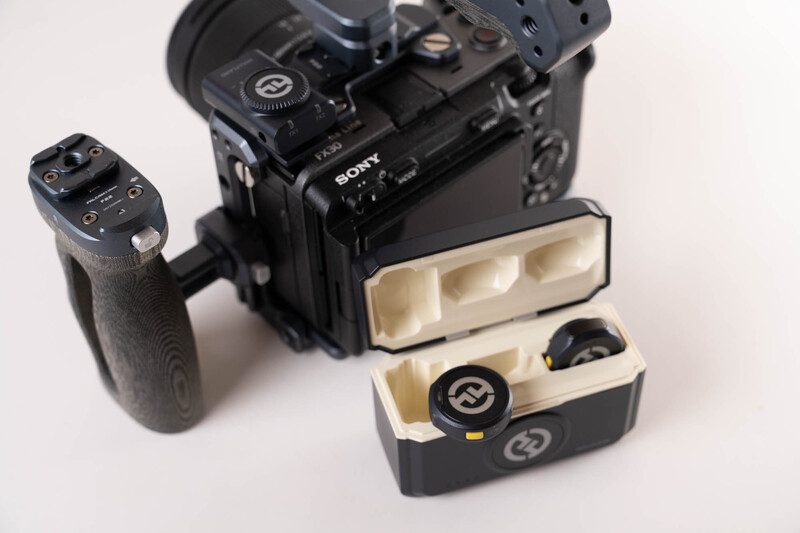 Sony camera body with external flash unit and wireless trigger system displayed with accessories.